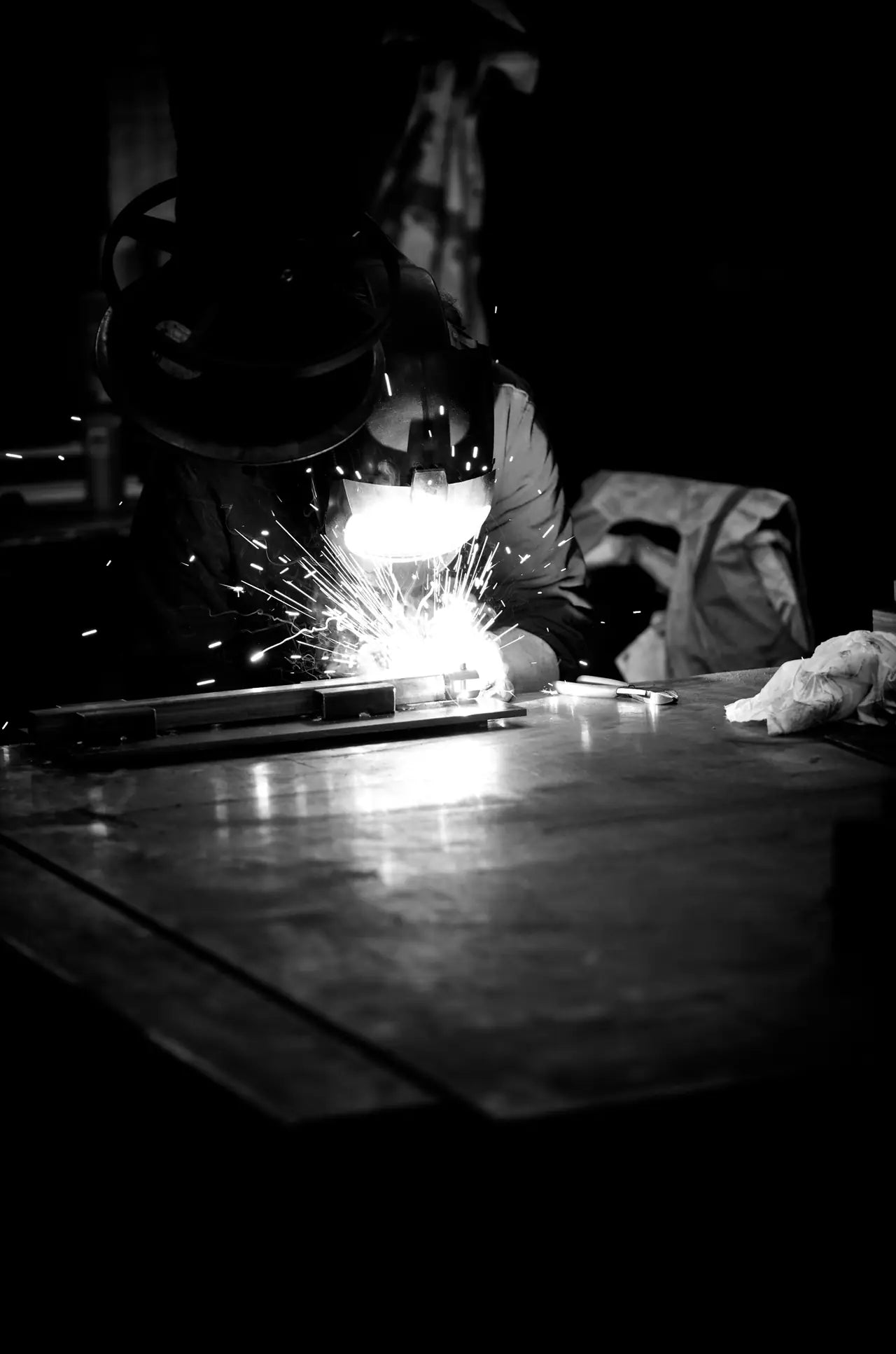 Sparks flying as metal is cut in a dark workshop